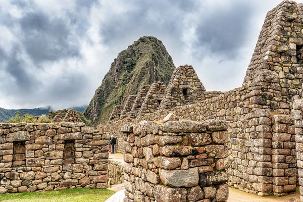 Peru 'daki Machu Picchu şehrindeki binalar ve evler. Wayna, Huayna Picchu dağ zirvesi arka planda.