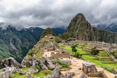 Peru 'daki Machu Picchu şehrindeki binalar ve evler. Wayna, Huayna Picchu dağ zirvesi arka planda.