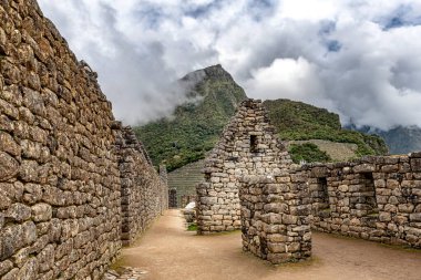 Peru 'nun Cusco kenti yakınlarındaki antik İnka şehri Machu Picchu' daki bina ve binalara bakın. Arka planda Machu Picchu dağı zirvesi.