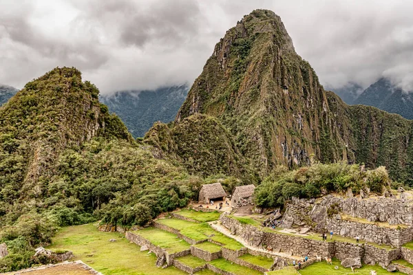 Peru 'daki Machu Picchu şehrindeki binalar ve evler. Wayna, Huayna Picchu dağ zirvesi arka planda.