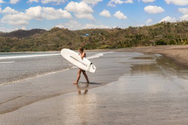 Venao plajı, Azuero, Panama - 16 Şubat 2020: Panama, Azuero yarımadasındaki Venao sahiline giren genç bayan sörfçü.,