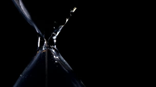 黒い背景と横方向の組成と可能な無限ループの外側の光バックライト砂時計の砂の流れ — ストック動画