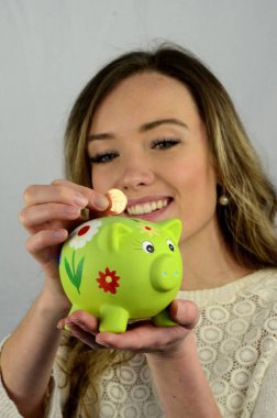 Genç çekici kadın bir kumbara Ystad, İsveç'te bir para koymak