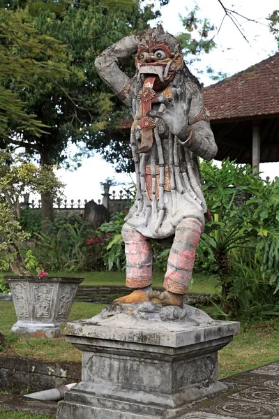 Stone statues of various Deities and demons (asuras) on the grounds of the water palace Tirtha Ganga, Bali, Indonesia