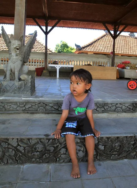 Foto Uma Menina Sentada Fundo Estátua Leão Com Asas Bali — Fotografia de Stock