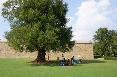 İnsanlar Hindu tapınaklarını ziyaret ettikten sonra parkta dinleniyorlar. Chidambaram Tapınak Şehri, Tamil Nadu, Hindistan