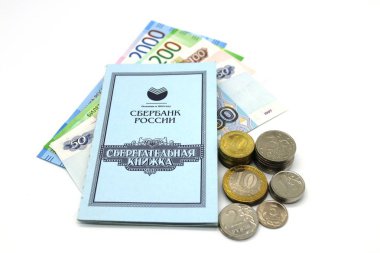 Tasarruf kitaba. Metal ve kağıt para beyaz bir arka plan üzerinde.