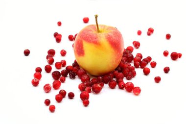 Bir elma ve beyaz zemin üzerine donmuş kızılcık