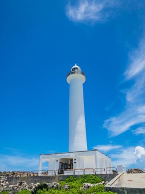 Yaz ferahlatıcı mavi gökyüzü ve Cape Zanpa Burnu deniz feneri, Okinawa 'da bir turistik yer.