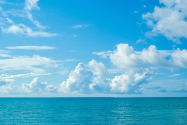 Okinawa 'nın ferahlatıcı mavi gökyüzü, yaz bulutları, sakin deniz ve ufuk.