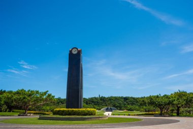 Mavi gökyüzündeki barış anıtı parkının saat kulesi ve Okinawa 'daki turistik yerler