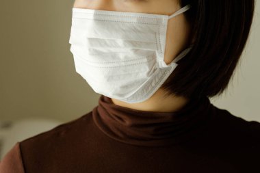 Enfeksiyonu önlemek için maske takan bir kadın.