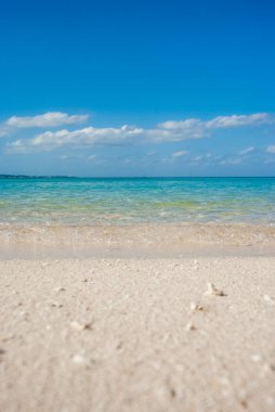 Mavi gökyüzü, beyaz sahil ve kristal berrak deniz