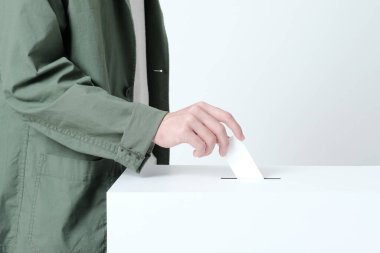 Hands of a young man putting a ballot in an election ballot box clipart