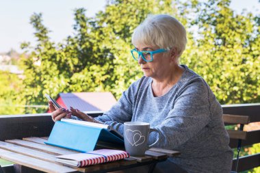 Sarışın saçlı güzel kadın kıdemli bir iş evde çalışır. Teras manzarası. Güneşli gün.