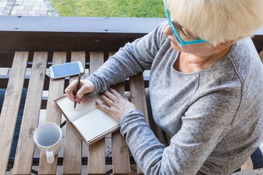 Sarışın saçlı güzel kadın kıdemli bir iş evde çalışır. Teras manzarası. Güneşli gün.