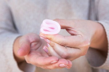 Adet Kupası kadın eliyle tutuyor. Seçici odak.