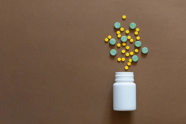 Żółte Zielone Tabletki Rozlany Białe Plastikowe Butelki Puste Tło Brązowy — Zdjęcie stockowe