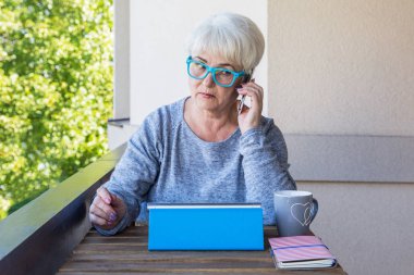 Sarışın saçlı güzel kadın kıdemli bir iş evde çalışır. Teras manzarası. Güneşli gün.