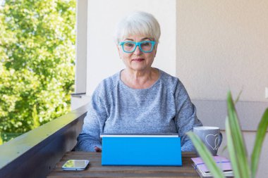 Sarışın saçlı güzel kadın kıdemli bir iş evde çalışır. Teras manzarası. Güneşli gün.