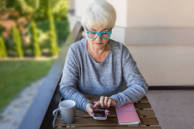 Sarışın saçlı güzel kadın kıdemli bir iş evde çalışır. Teras manzarası. Güneşli gün.