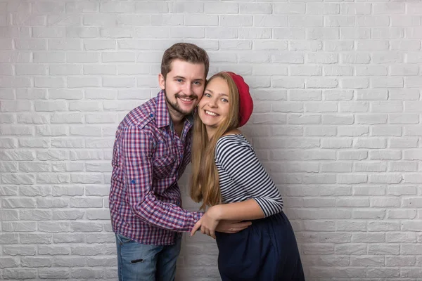 A happy funny couple in love enjoys Valentine\'s Day. A man with a beard and a woman with long blond hair and a red beret.