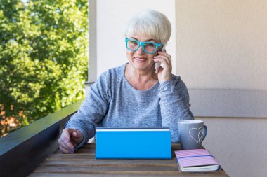 Sarışın saçlı güzel kadın kıdemli bir iş evde çalışır. Teras manzarası. Güneşli gün.