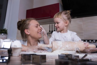 Mutlu bir aile! Küçük bir kızı kurabiye pişirmeye annesi ile mutfakta vakit geçiriyor. Anneler günü.