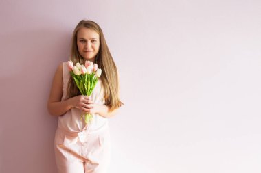 Sarı çözünmüş uzun saçlı, keçe şapka başında, güzel bir genç kızla bahar çiçekleri güneşli bir günde elinde tutar. Kadınlar günü.