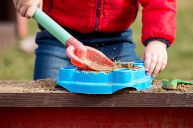 Sanal eğlenceli. Çocuğun elele bir kürek ve bir süzgeç. Seçici odak, yakın.