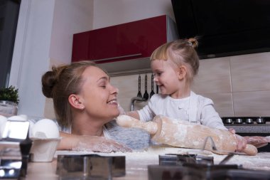 Mutlu bir aile! Küçük bir kızı kurabiye pişirmeye annesi ile mutfakta vakit geçiriyor. Anneler günü.