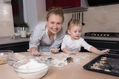 Mutlu bir aile! Küçük bir kızı kurabiye pişirmeye annesi ile mutfakta vakit geçiriyor. Anneler günü.