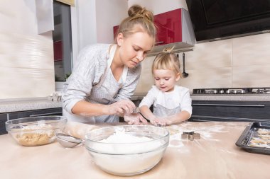 Mutlu bir aile! Küçük bir kızı kurabiye pişirmeye annesi ile mutfakta vakit geçiriyor. Anneler günü.