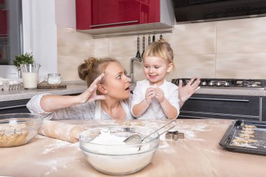 Mutlu bir aile! Küçük bir kızı kurabiye pişirmeye annesi ile mutfakta vakit geçiriyor. Anneler günü.