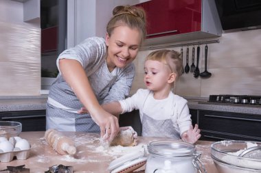 Mutlu bir aile! Küçük bir kızı kurabiye pişirmeye annesi ile mutfakta vakit geçiriyor. Anneler günü.