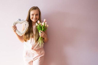Sarı çözünmüş uzun saçlı, keçe şapka başında, güzel bir genç kızla bahar çiçekleri güneşli bir günde elinde tutar. Kadınlar günü.