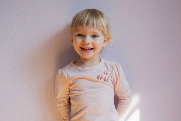 Szczęśliwy Blond Dziewczynka Stoi Oparty Ścianę Słoneczny Pokój Domu Ona — Zdjęcie stockowe