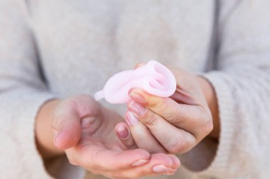 Adet Kupası kadın eliyle tutuyor. Seçici odak.