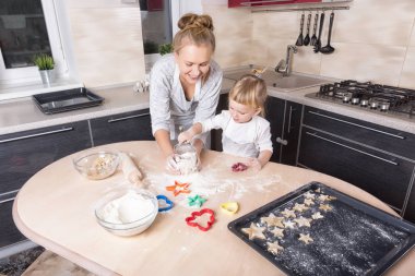 Mutlu bir aile! Küçük bir kızı kurabiye pişirmeye annesi ile mutfakta vakit geçiriyor. Anneler günü.