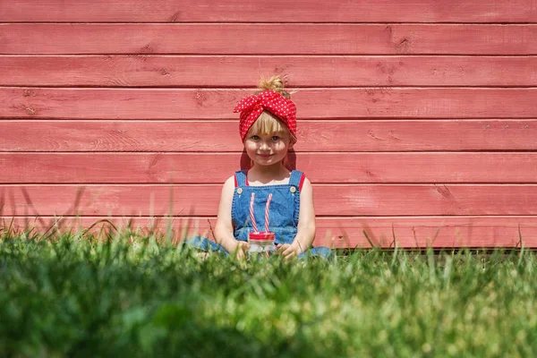 Liten Flicka Hängselbyxa Dricker Mjölk Från Burk Röd Bakgrund Kopia — Stockfoto