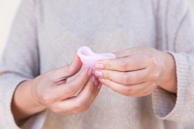 Adet Kupası kadın eliyle tutuyor. Seçici odak.