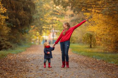 Mutlu anne ve kızı bir sonbahar Park'ta yürüyordunuz.