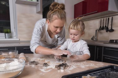 Mutlu bir aile! Küçük bir kızı kurabiye pişirmeye annesi ile mutfakta vakit geçiriyor. Anneler günü.