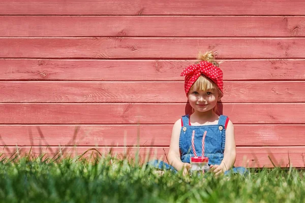 Liten Flicka Hängselbyxa Dricker Mjölk Från Burk Röd Bakgrund Kopia — Stockfoto