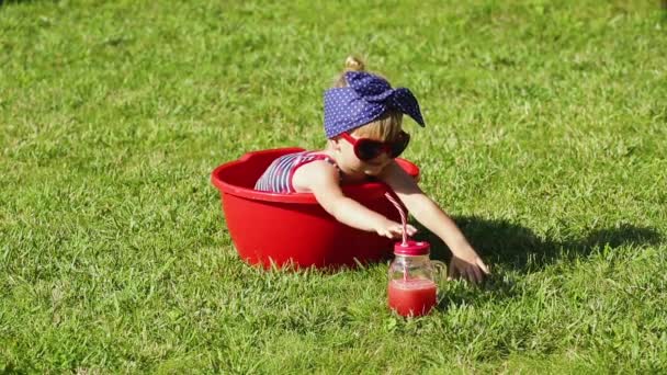 petite fille joue dans la nature avec des lunettes de soleil rouges