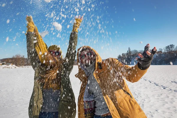 Due giovani felici che lanciano neve e si divertono. Selettivo f — Foto Stock