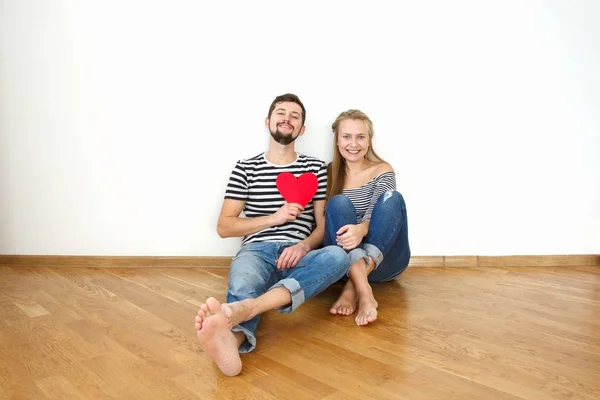 Happy valentines couple sitting on a wooden floor. White background copy space