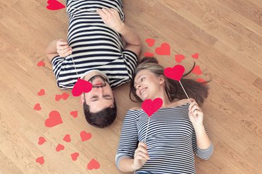 Üstten görünüm genç çift yerde yatarken ve kamera ve gülümseme için arıyorum.