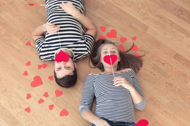 Üstten görünüm genç çift yerde yatarken ve kamera ve gülümseme için arıyorum.