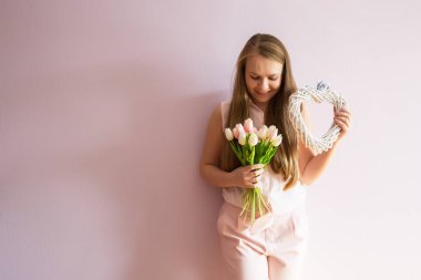 Sarı çözünmüş uzun saçlı, keçe şapka başında, güzel bir genç kızla bahar çiçekleri güneşli bir günde elinde tutar. Kadınlar günü.